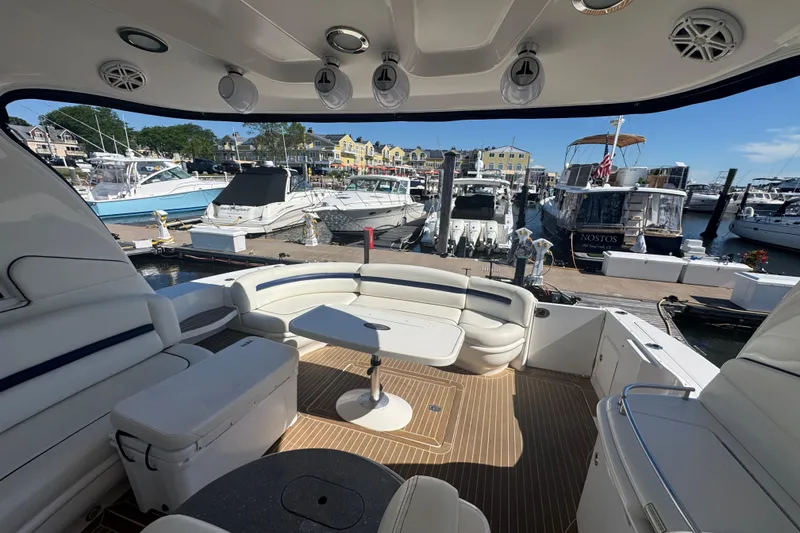 Slide: The Image of Luxurious 2006 Sea Ray 52 Sundancer yacht interior at marina, featuring spacious seating and table. - 8