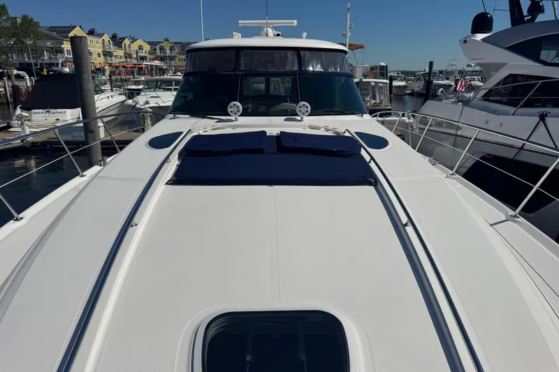 Slide: The Image of 2006 Sea Ray 52 Sundancer yacht docked at marina, showcasing sleek design and spacious deck. - 26