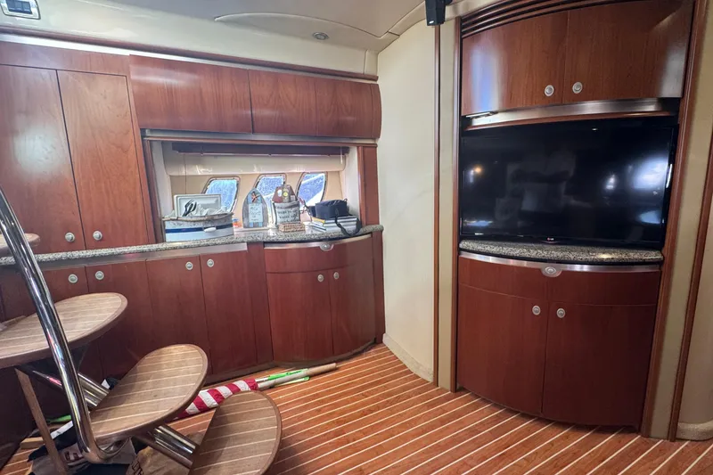 Slide: The Image of Luxurious interior of 2006 Sea Ray 52 Sundancer yacht with wood cabinetry and TV. - 19