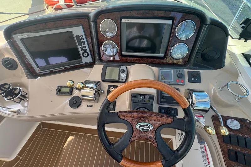 Slide: The Image of 2006 Sea Ray 52 Sundancer helm with wood accents and modern navigation equipment. - 7
