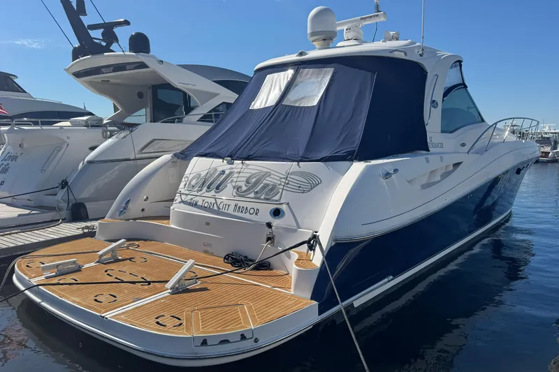 Slide: The Image of 2006 Sea Ray 52 Sundancer yacht docked, featuring sleek design and blue hull. - 1