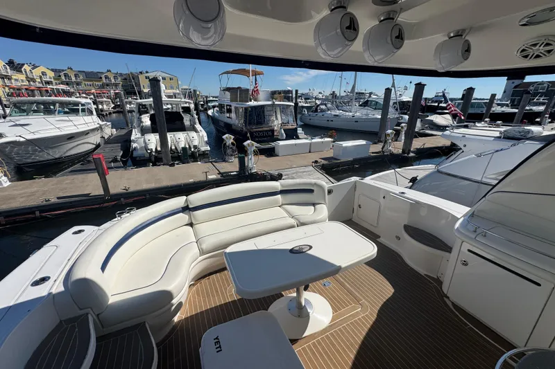 Slide: The Image of Luxurious 2006 Sea Ray 52 Sundancer yacht interior at marina, featuring elegant seating and table. - 9
