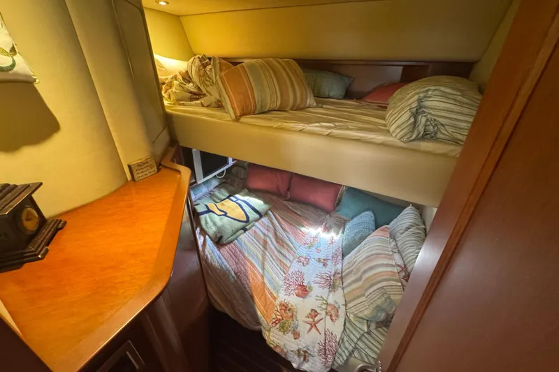 Slide: The Image of Interior of 2006 Sea Ray 52 Sundancer yacht with cozy bunk beds and wooden cabinetry. - 15