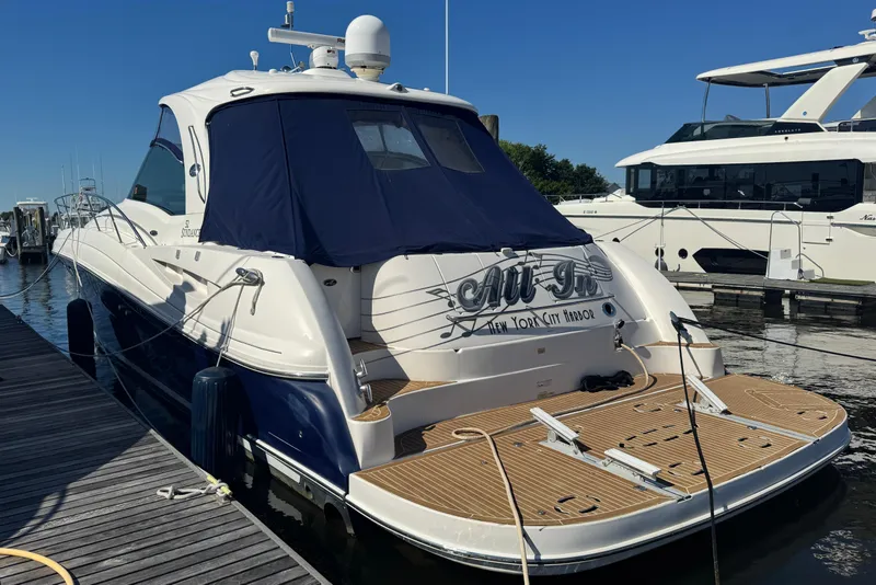 Slide: The Image of 2006 Sea Ray 52 Sundancer yacht docked at marina, featuring sleek design and blue canopy. - 3