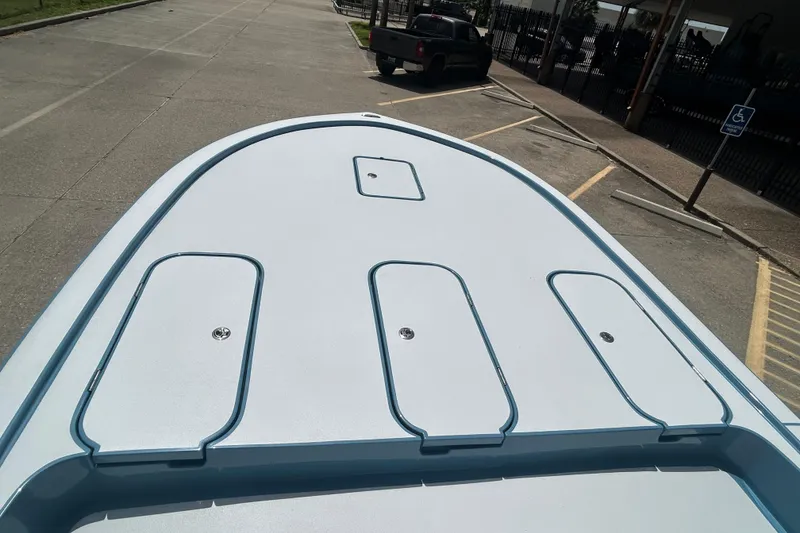 Slide: The Image of 2026 Shallow Sport 25 X3 boat deck in a parking lot, showcasing storage compartments. - 6