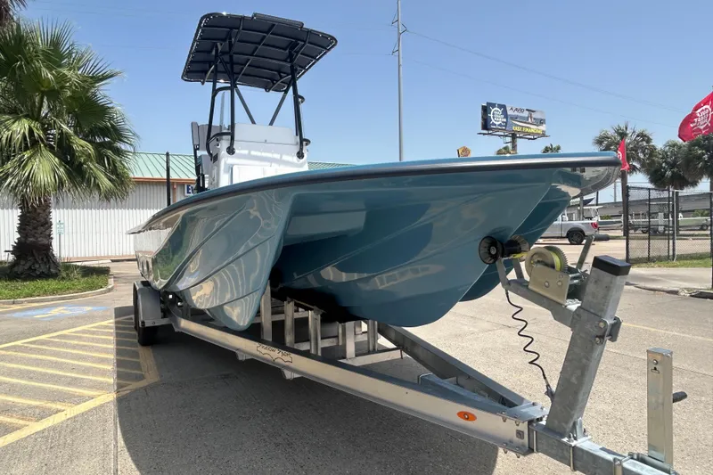 Slide: The Image of 2026 Shallow Sport 25 X3 boat on trailer, parked outdoors under clear sky. - 3