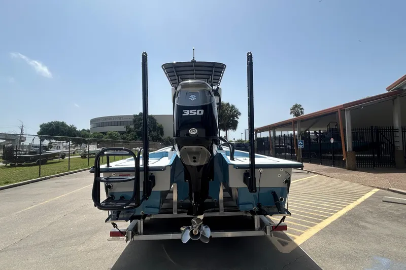 Slide: The Image of Shallow Sport 25 X3 boat, 2026 model, with Suzuki 350 engine, parked outdoors. - 4