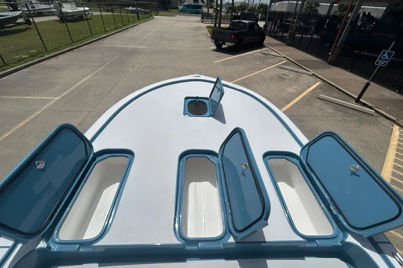 Slide: The Image of 2026 Shallow Sport 25 X3 boat with open storage compartments on deck. - 7