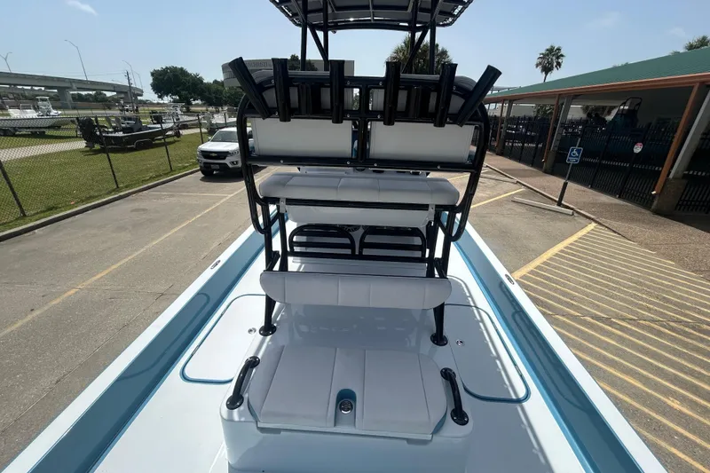 Slide: The Image of 2026 Shallow Sport 25 X3 boat with seating and storage, parked in a lot. - 18