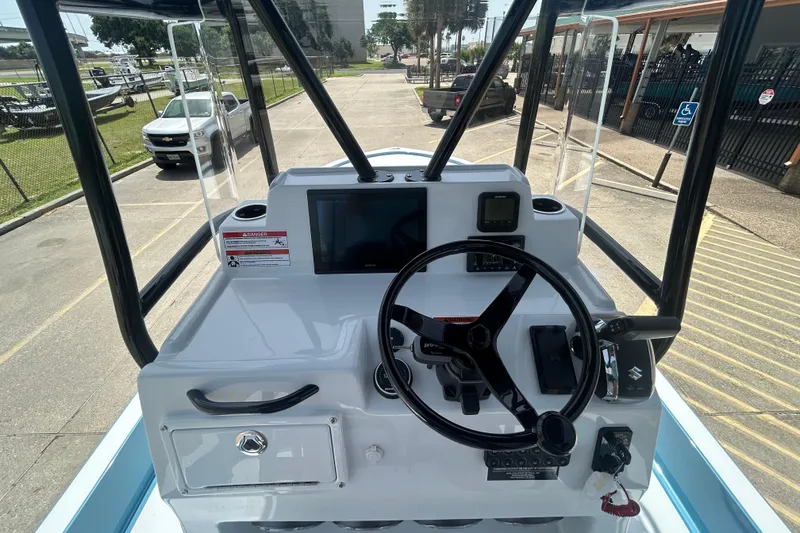 Slide: The Image of 2026 Shallow Sport 25 X3 boat dashboard with steering wheel and navigation controls. - 21