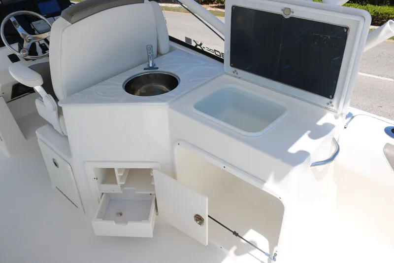Slide: The Image of 2022 World Cat 280 DC-X boat interior with sink, storage, and seating. - 14