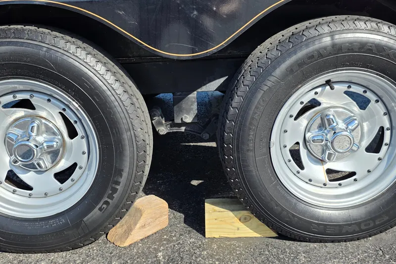 Slide: The Image of Dual wheels of a 2012 Nitro Z-7 trailer, secured with wooden chocks. - 27