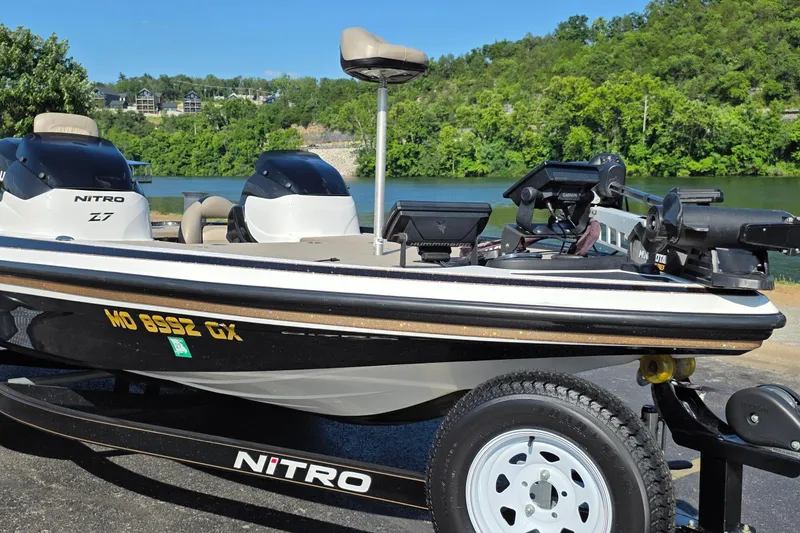 Slide: The Image of 2012 Nitro Z-7 boat on trailer by a scenic lake with lush greenery. - 4