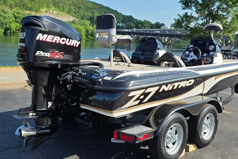 Slide: The Image of 2012 Nitro Z-7 boat with Mercury Pro XS engine, parked near a scenic river. - 6