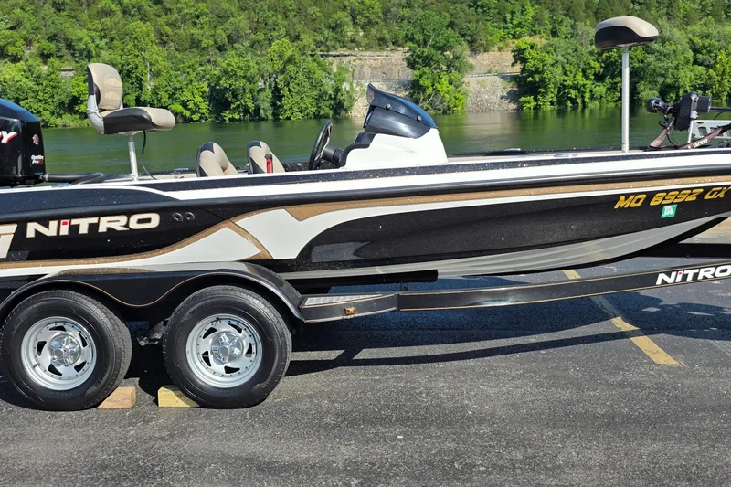 The Image of 2012 Nitro Z-7 boat on trailer by a river, surrounded by lush greenery. - 1