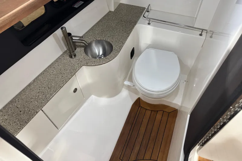 Slide: The Image of 2016 Sea Ray SLX 350 boat bathroom with sink, toilet, and wooden floor mat. - 11