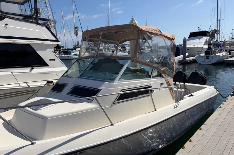 Slide: The Image of 1991 Donzi 255 LXC boat docked at marina, featuring a beige canopy and sleek design. - 3