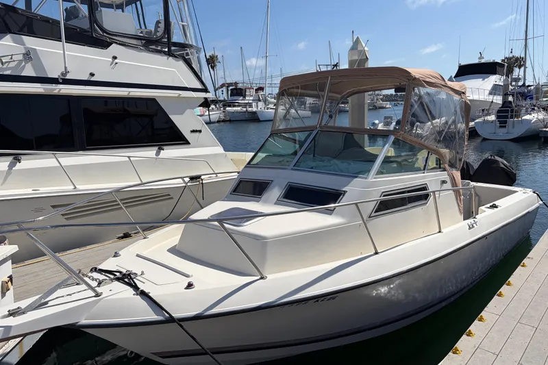 Slide: The Image of 1991 Donzi 255 LXC boat docked at marina, featuring sleek design and beige canopy. - 2