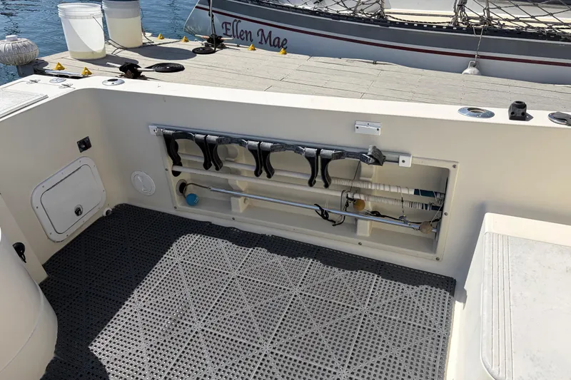 Slide: The Image of 1991 Donzi 255 LXC boat interior with storage compartment and fishing rod holders. - 6