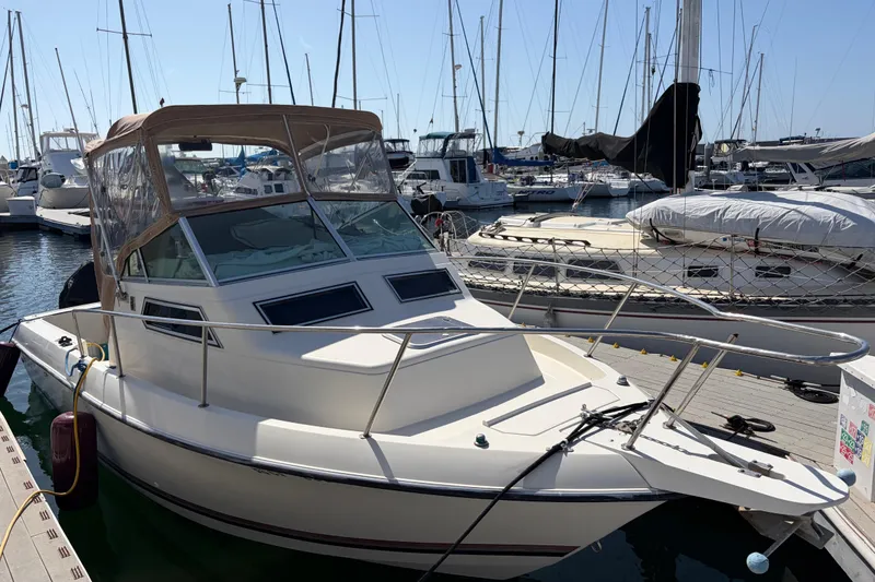 Slide: The Image of 1991 Donzi 255 LXC boat docked in a marina, surrounded by other vessels. - 1
