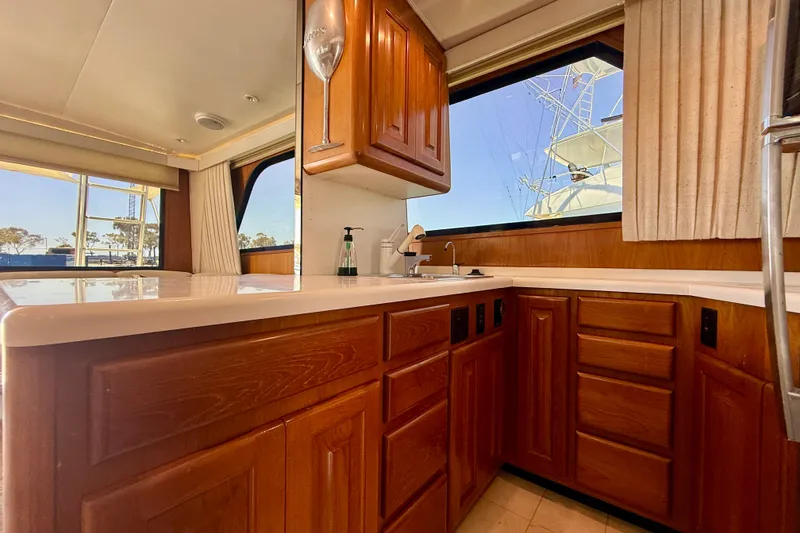 Slide: The Image of Luxurious kitchen interior of a 1994 Viking 47 Convertible yacht with wooden cabinetry. - 21