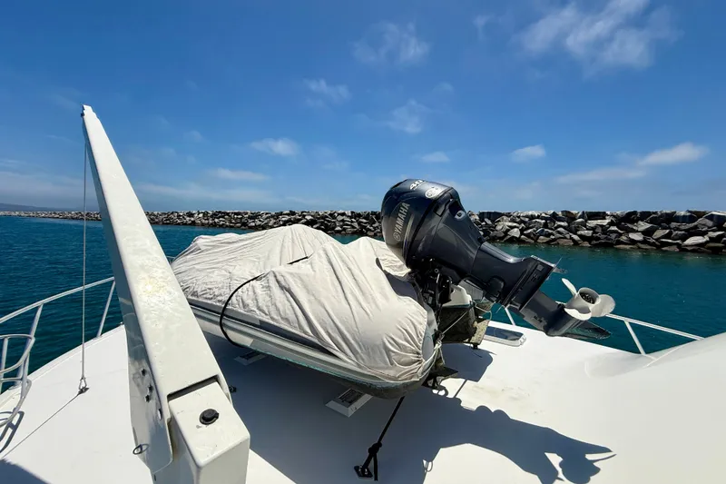 Slide: The Image of Bow of 1994 Viking 47 Convertible with covered dinghy and Yamaha outboard motor. - 68