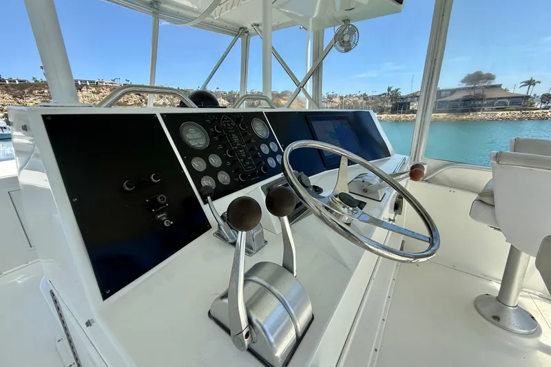 Slide: The Image of Control panel of a 1994 Viking 47 Convertible yacht with steering wheel and gauges. - 54