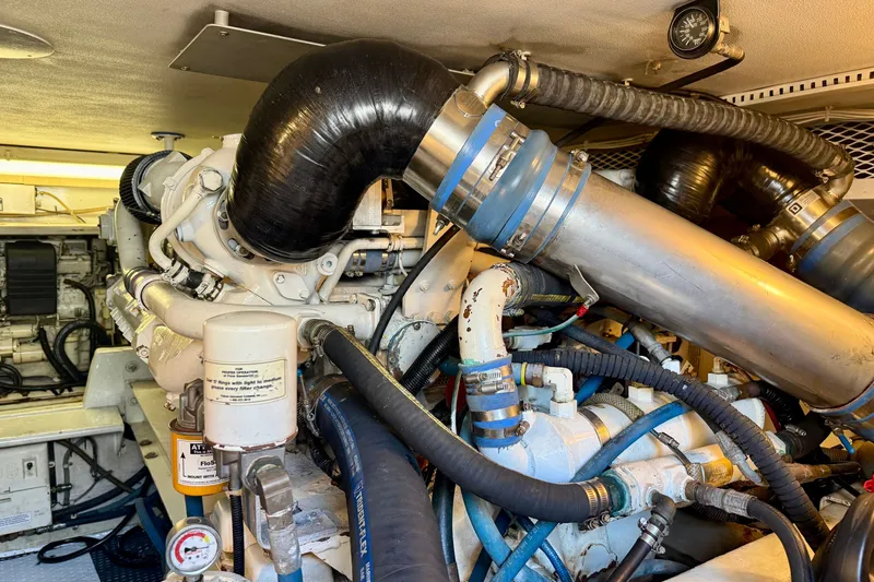 Slide: The Image of Engine room of a 1994 Viking 47 Convertible yacht, showcasing complex machinery and piping. - 71