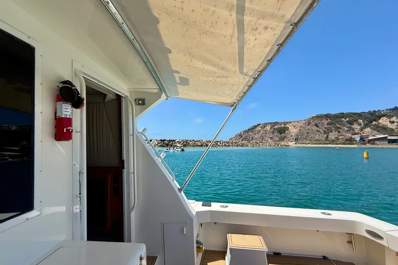 Slide: The Image of 1994 Viking 47 Convertible yacht with ocean view and coastal backdrop. - 43