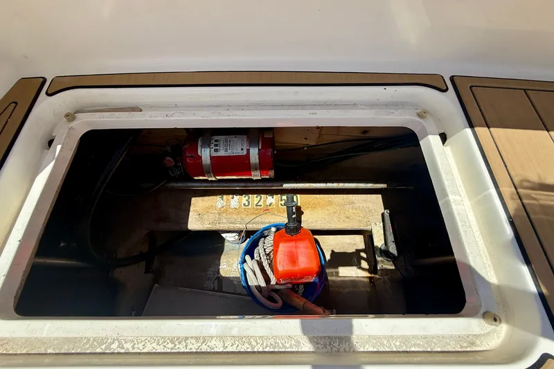 Slide: The Image of Storage compartment of a 1994 Viking 47 Convertible boat with equipment and fire extinguisher. - 53