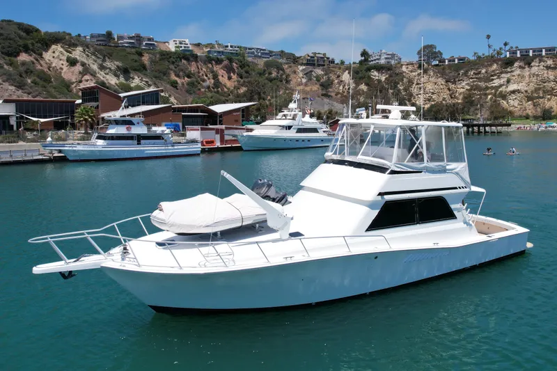 Slide: The Image of 1994 Viking 47 Convertible yacht docked in scenic marina setting. - 4