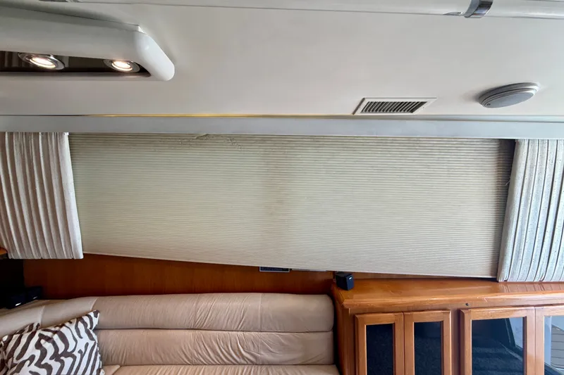 Slide: The Image of Interior of a 1994 Viking 47 Convertible yacht with beige sofa and wooden cabinets. - 23
