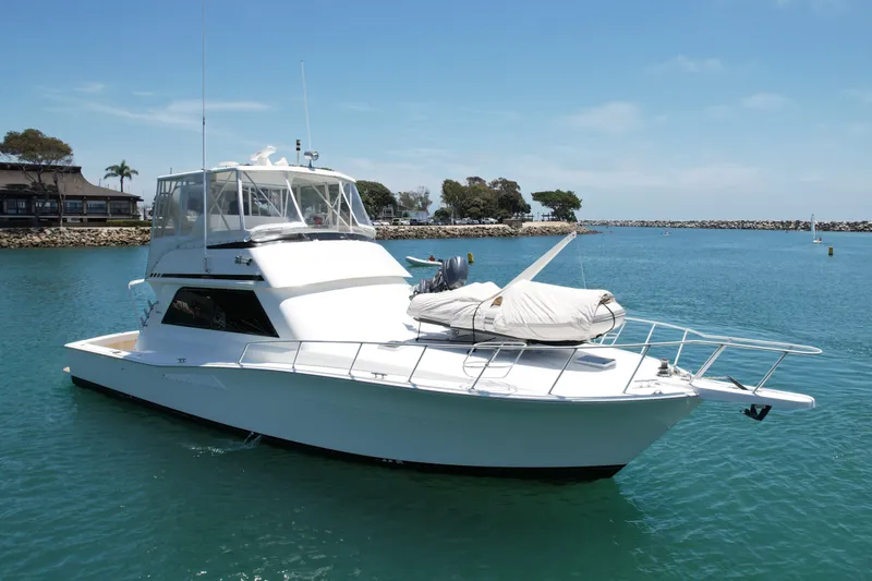 Slide: The Image of 1994 Viking 47 Convertible yacht docked in a serene marina setting. - 7