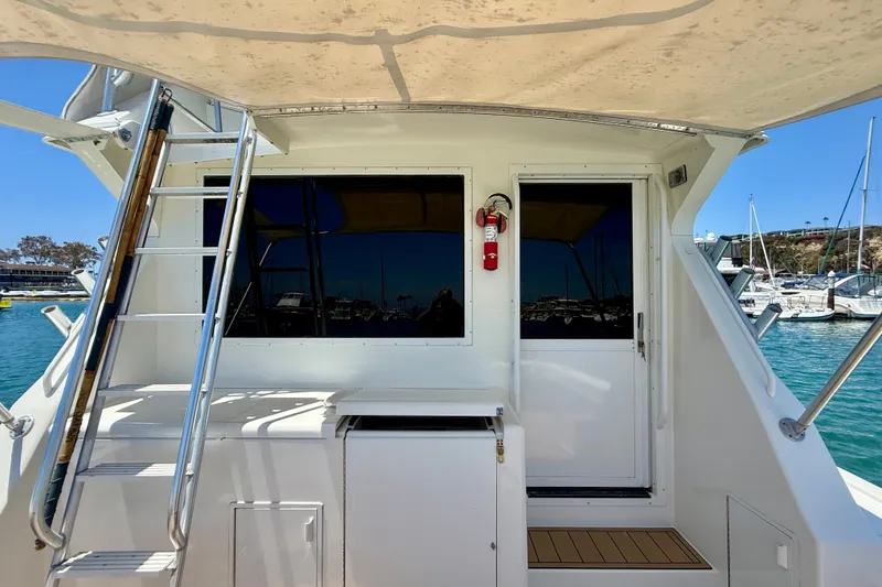 Slide: The Image of 1994 Viking 47 Convertible yacht with ladder and door, docked in a marina. - 80