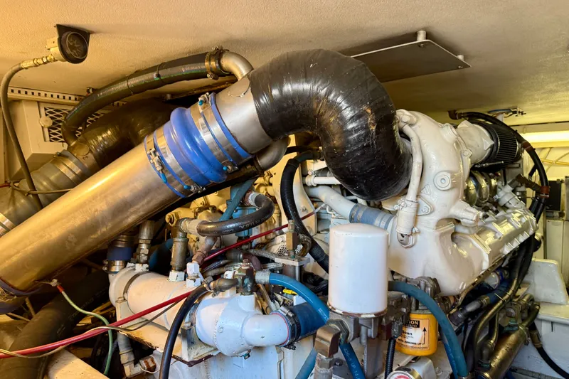 Slide: The Image of Engine room of a 1994 Viking 47 Convertible yacht, showcasing complex machinery and piping. - 72