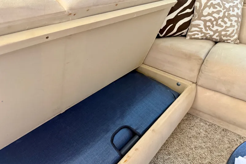 Slide: The Image of Storage compartment in a 1994 Viking 47 Convertible boat with beige seating and patterned cushions. - 48