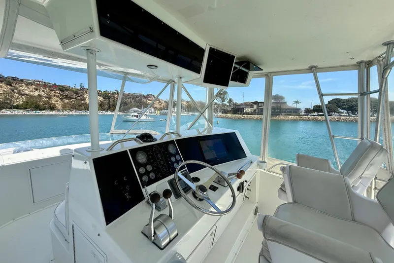 Slide: The Image of Interior view of 1994 Viking 47 Convertible yacht helm with scenic marina backdrop. - 55