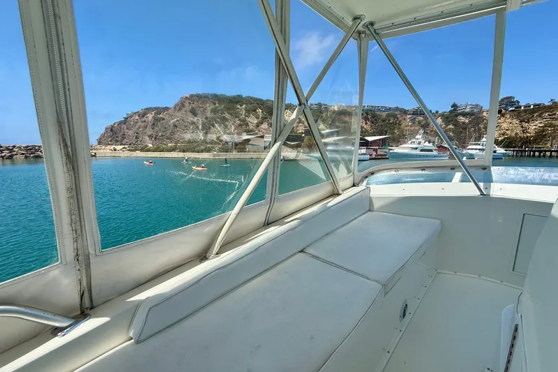 Slide: The Image of View from 1994 Viking 47 Convertible yacht, overlooking serene coastal waters and rocky cliffs. - 58