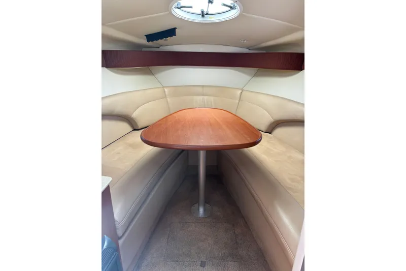 Slide: The Image of 2007 Maxum 2600 SE cabin interior with beige seating and wooden table. - 14