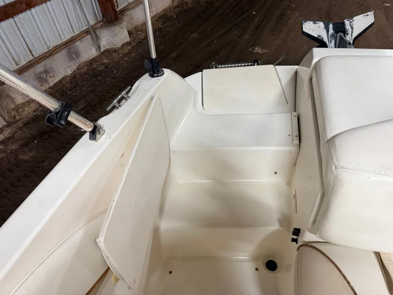 Slide: The Image of Interior view of a Glastron DX215 deck boat with white seating and storage area. - 47