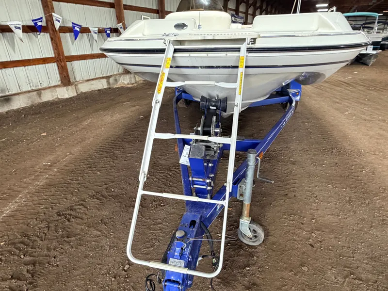 Slide: The Image of A 2003 Glastron DX215 deck boat on a trailer in a warehouse. - 12