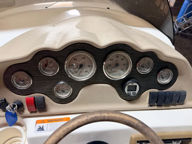 Slide: The Image of Dashboard of a Glastron DX215 Deck Boat with various gauges and switches. - 29