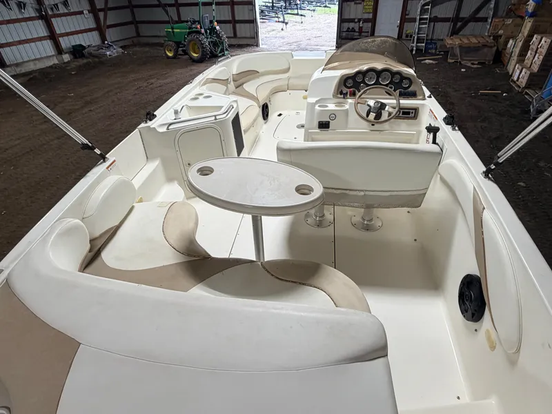 Slide: The Image of Interior view of a Glastron DX215 deck boat with cream-colored seating and a round table. - 8
