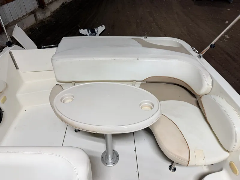 Slide: The Image of Interior view of a boat with white seating and a table featuring cup holders. - 9