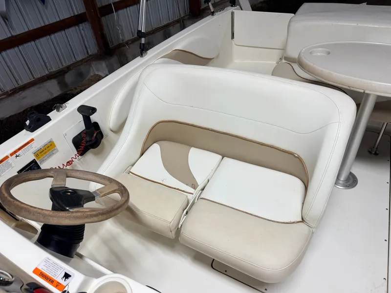 Slide: The Image of Interior of a Glastron DX215 deck boat with white upholstery and steering wheel. - 26