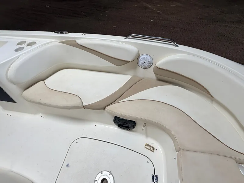 Slide: The Image of The image shows the seating area of a Glastron DX215 deck boat with beige upholstery. - 17