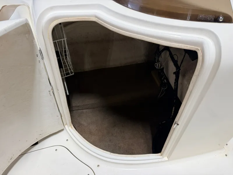 Slide: The Image of An open storage compartment on a boat with carpeted floor and a wire basket. - 25