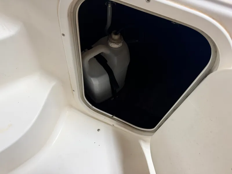 Slide: The Image of A white canister is visible inside a dark storage compartment on a boat. - 35