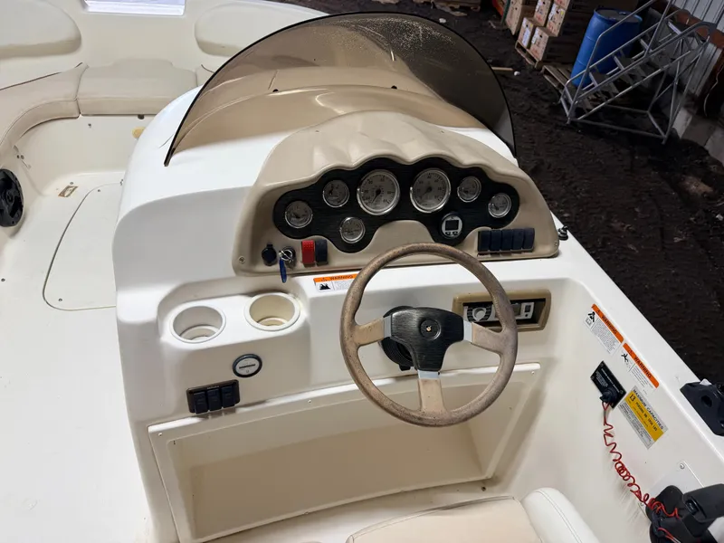 Slide: The Image of The image shows the cockpit of a Glastron DX215 deck boat with a steering wheel and various gauges. - 28