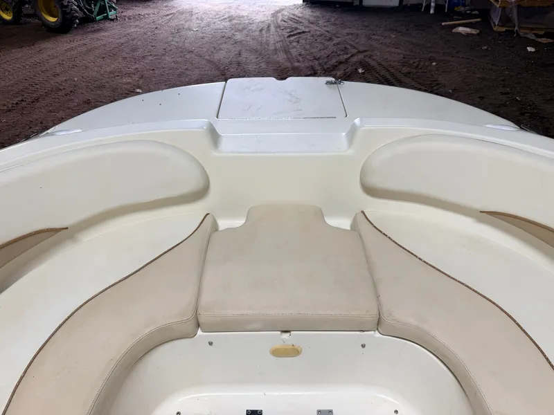 Slide: The Image of The image shows the bow of a Glastron DX215 deck boat with beige cushions. - 19